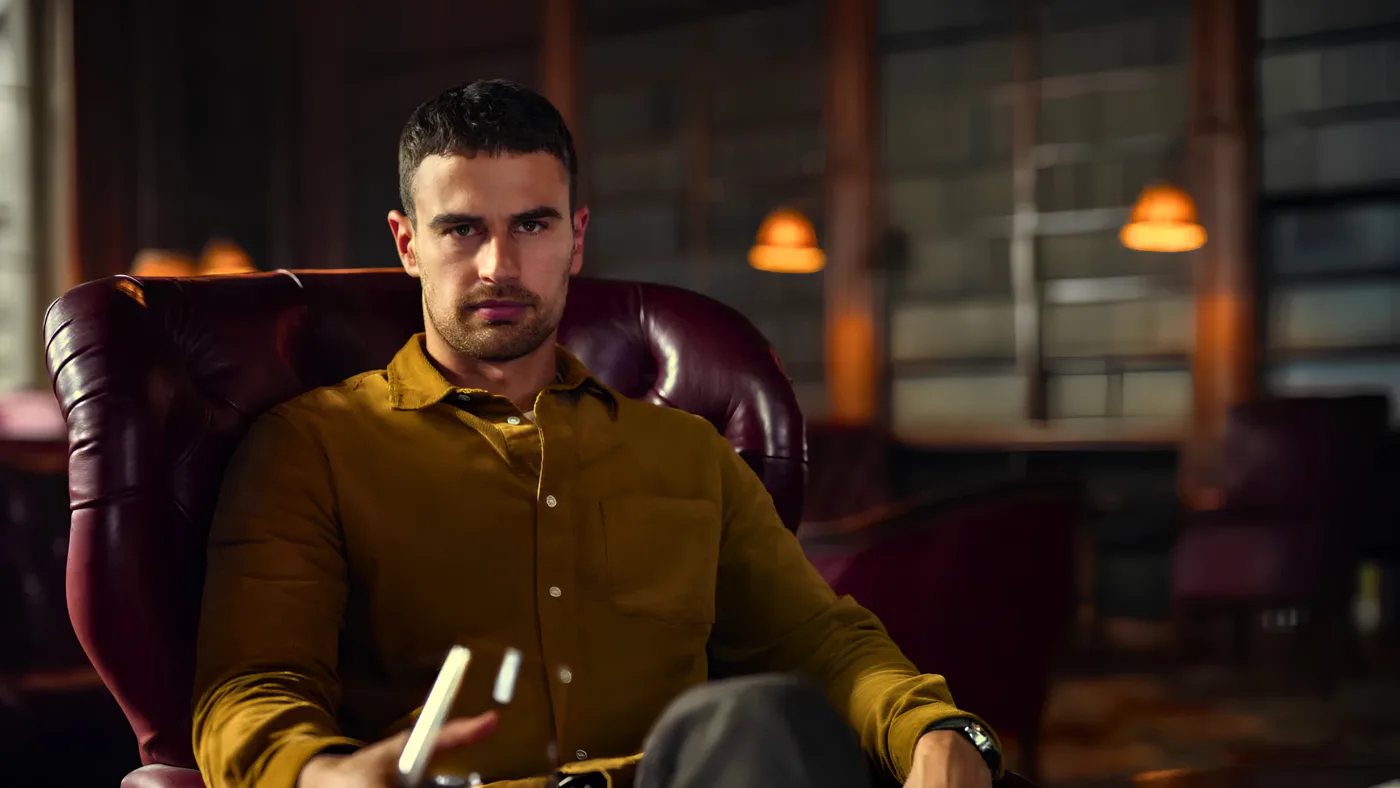 The same man in the leather armchair, graded darker, the scene scored as a drama by film composer Santiago Bianchi